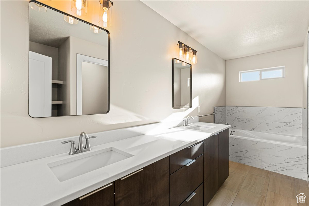 Bathroom with double vanity and a tub with marble appearance