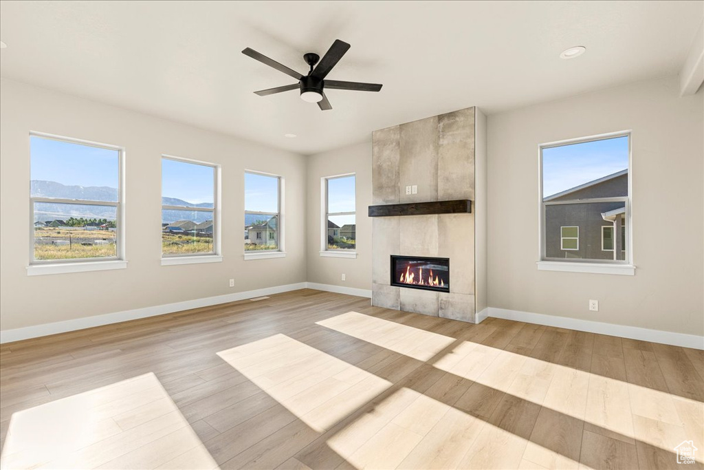 Unfurnished living room with plenty of natural light, baseboards, a fireplace, and recessed lighting
