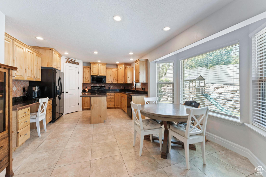 Kitchen featuring dark countertops, black appliances, plenty of natural light, backsplash, and recessed lighting