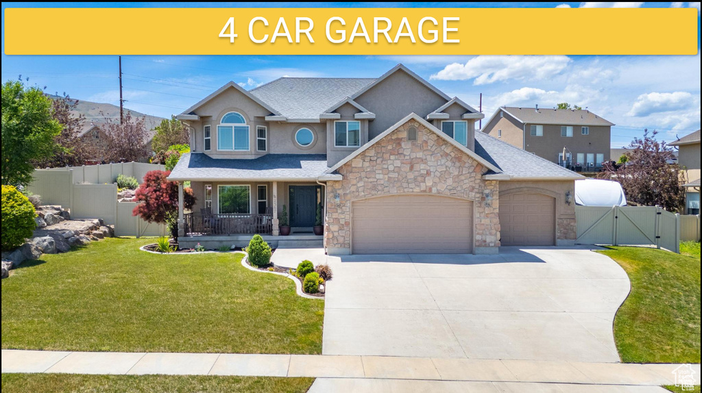 View of front of house featuring a gate, stone siding, an attached garage, covered porch, and stucco siding