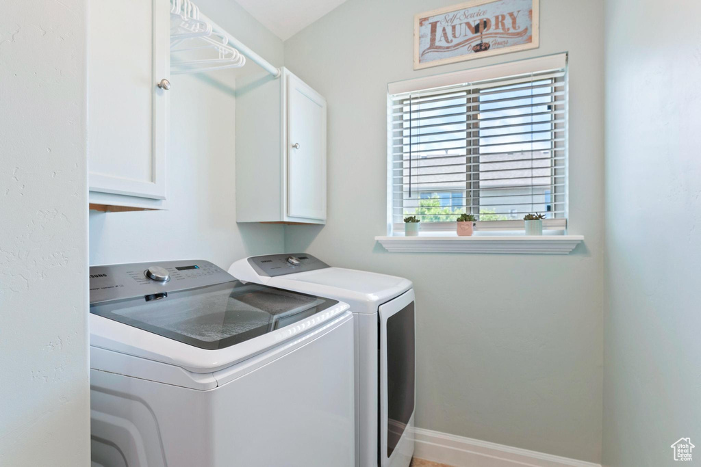 Laundry area featuring cabinet space, washer and clothes dryer, and baseboards