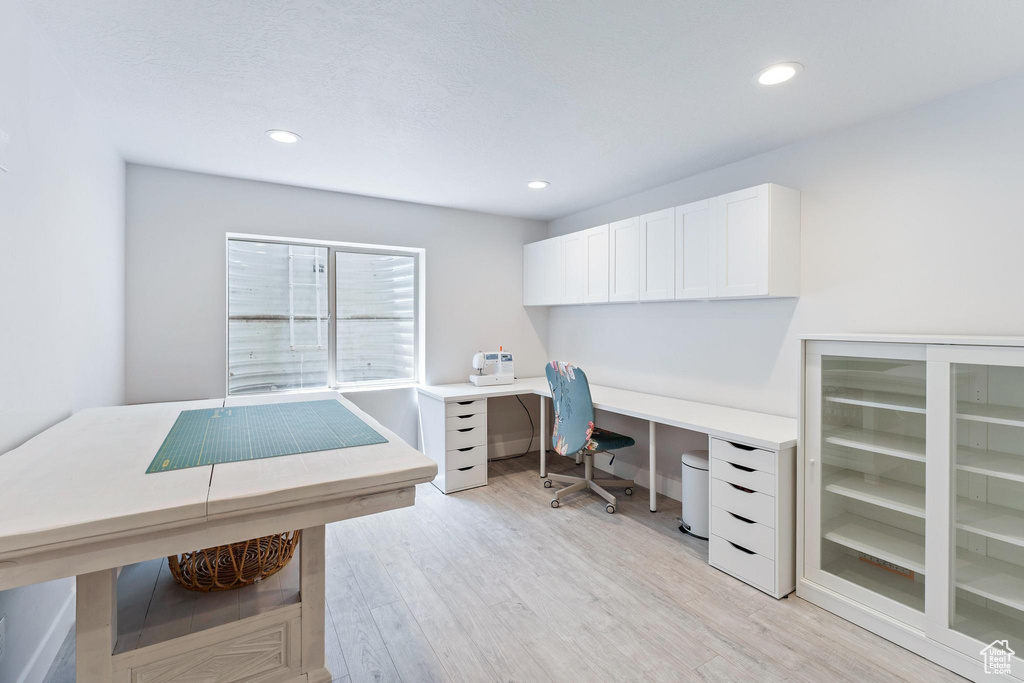 Office space featuring light wood-type flooring, recessed lighting, and beverage cooler
