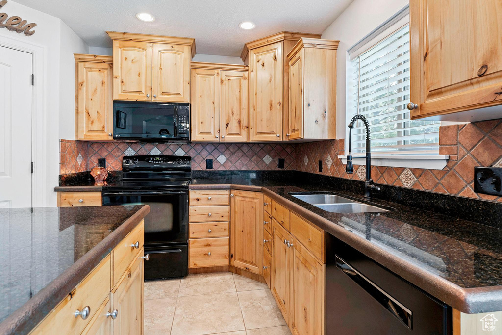 Kitchen featuring black appliances, light brown cabinetry, a sink, light tile patterned flooring, and recessed lighting