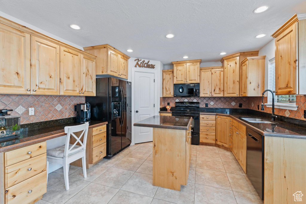 Kitchen featuring black appliances, a sink, light brown cabinets, a kitchen island, and recessed lighting