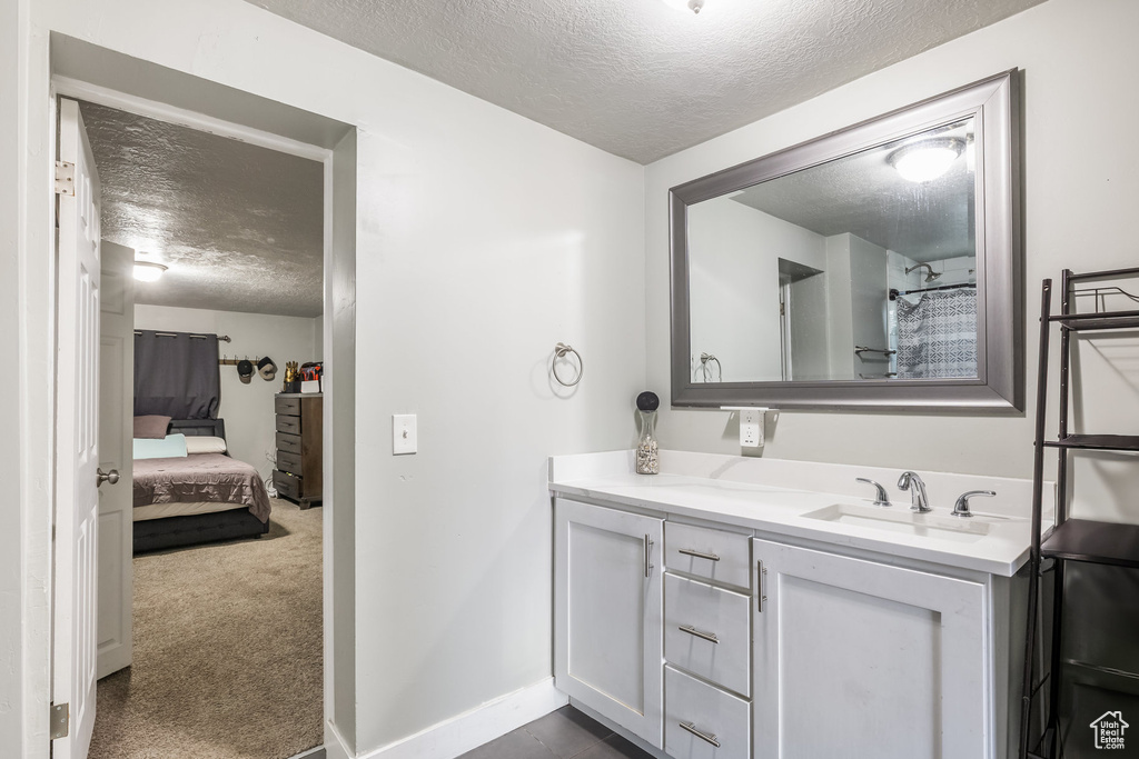 Ensuite bathroom with a textured ceiling and vanity