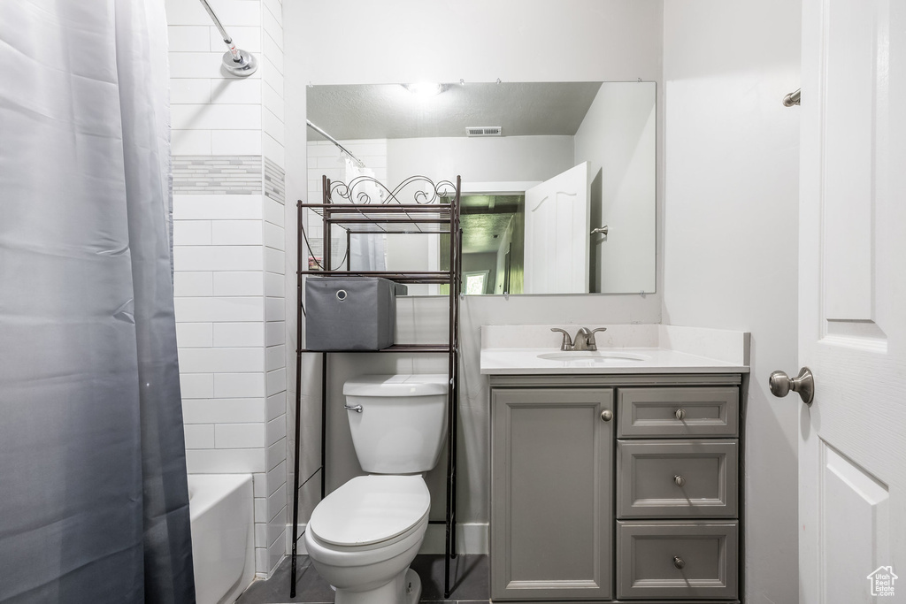 Full bath featuring vanity, toilet, and shower / bath combo