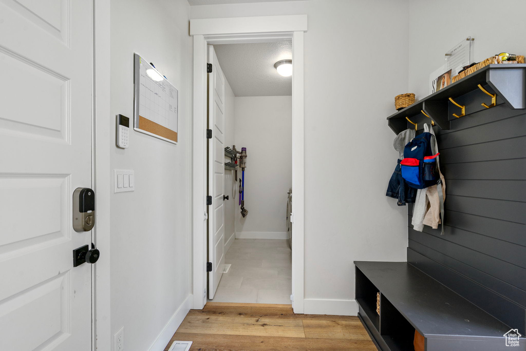 Mudroom featuring light wood-style floors and baseboards