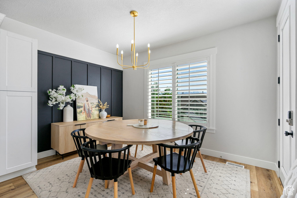 Dining area featuring a chandelier, light wood finished floors, and baseboards