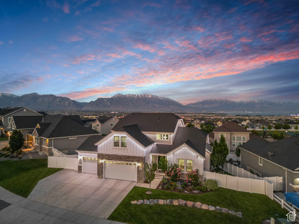 View of front of property featuring board and batten siding, a garage, a mountain view, and a residential view