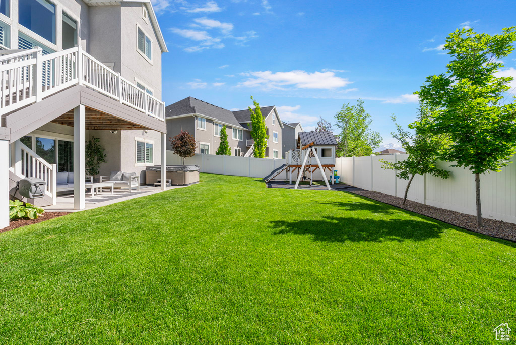 View of yard with a hot tub, a playground, a patio area, and a residential view
