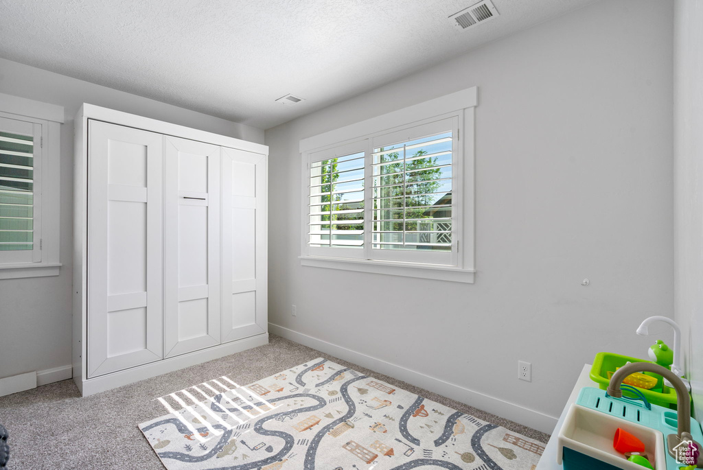 Bedroom with baseboards, carpet flooring, and a closet