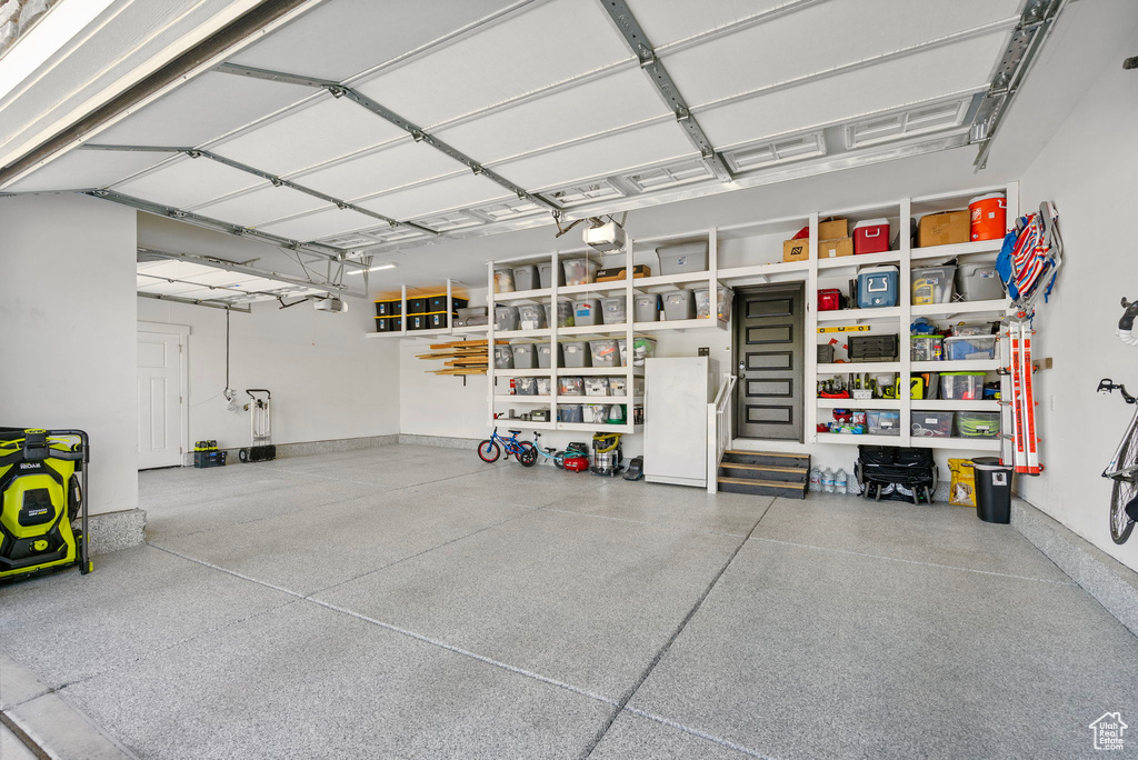 Garage featuring a garage door opener and baseboards