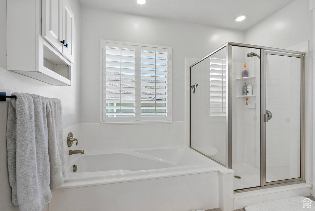 Full bath featuring a bath, a shower stall, and recessed lighting
