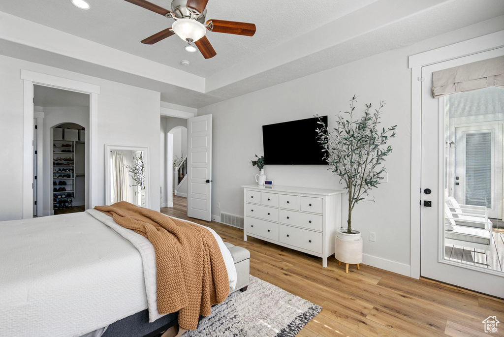 Bedroom with arched walkways, baseboards, light wood-style flooring, recessed lighting, and a ceiling fan