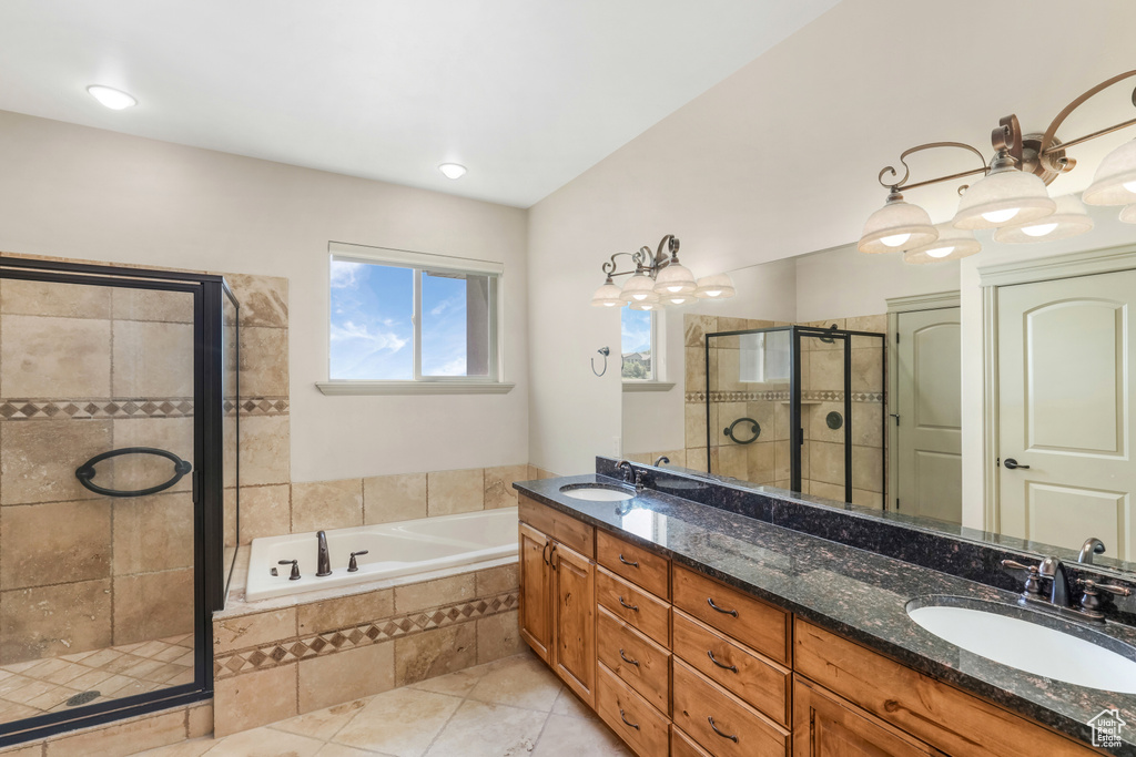 Full bath featuring a stall shower, a bath, double vanity, and tile patterned floors