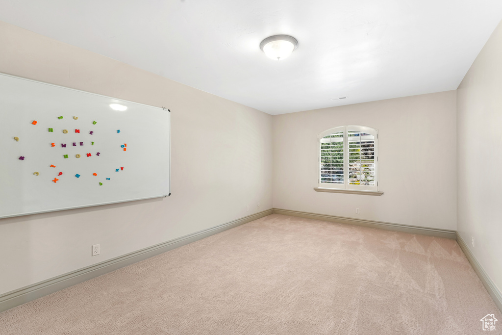 Carpeted spare room with baseboards