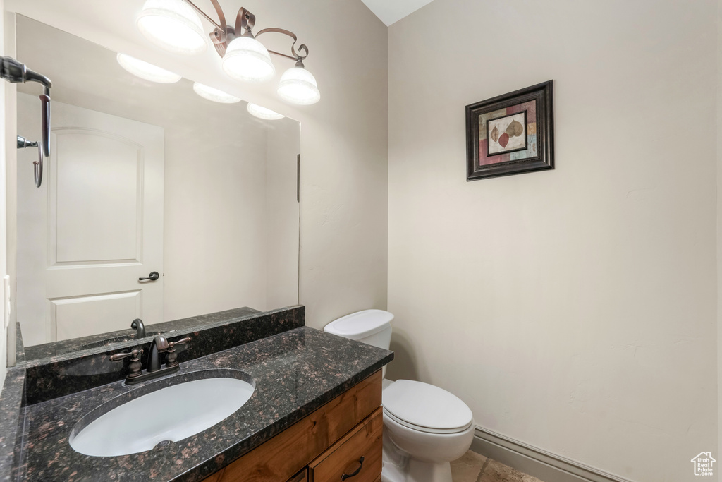 Bathroom with toilet, vanity, and tile patterned flooring