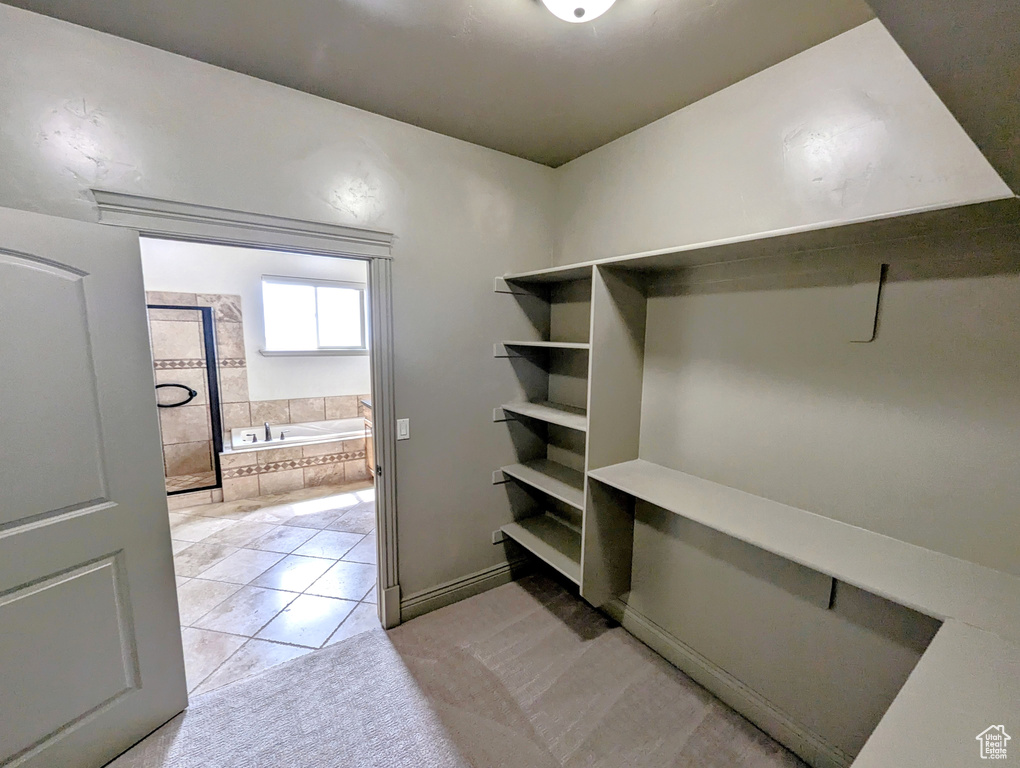 Spacious closet with light tile patterned floors