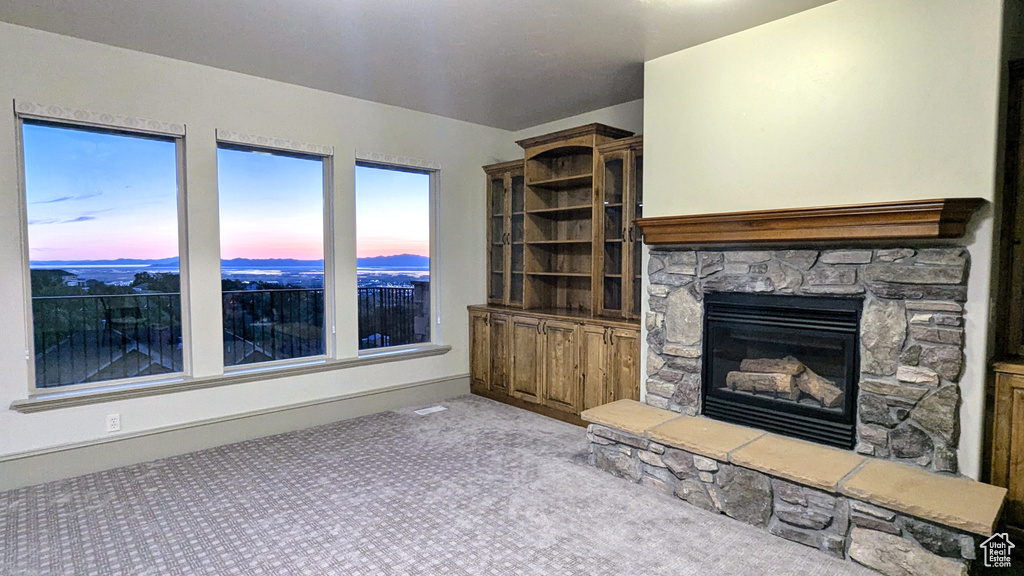 Unfurnished living room featuring a fireplace and carpet