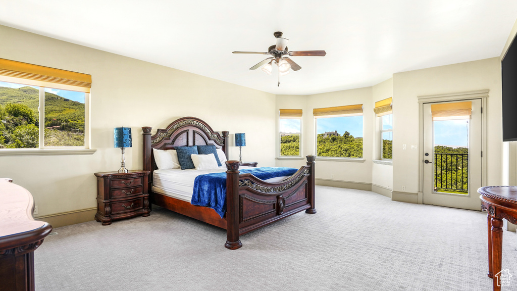 Carpeted bedroom with access to outside, multiple windows, baseboards, and a ceiling fan