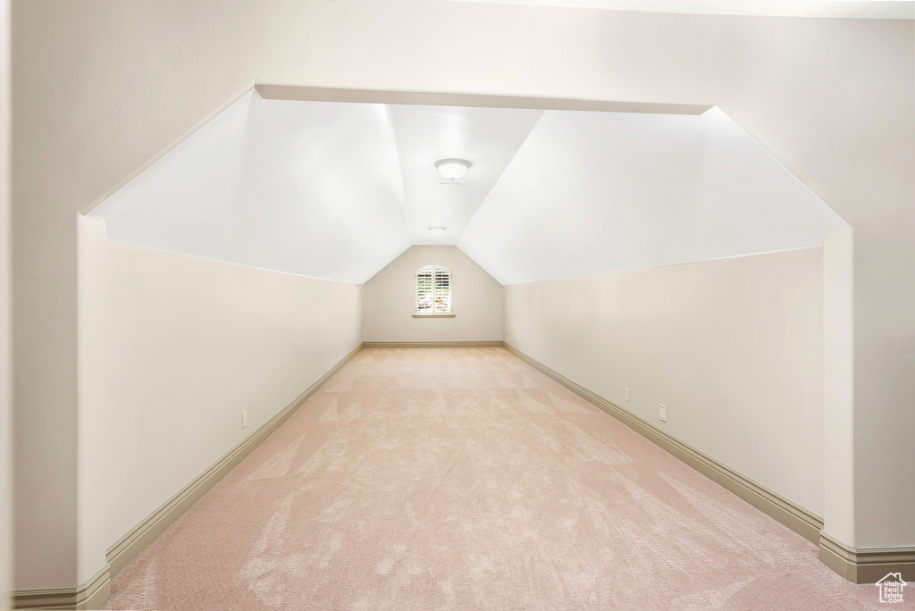 Bonus room featuring carpet flooring, vaulted ceiling, and baseboards