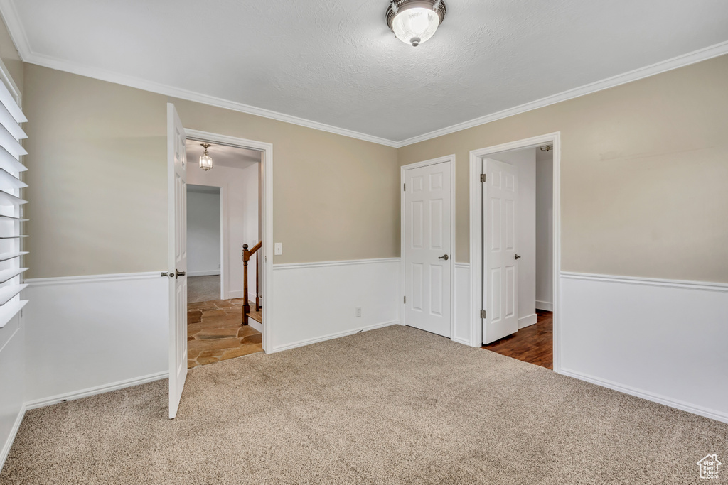 Unfurnished bedroom featuring carpet and crown molding