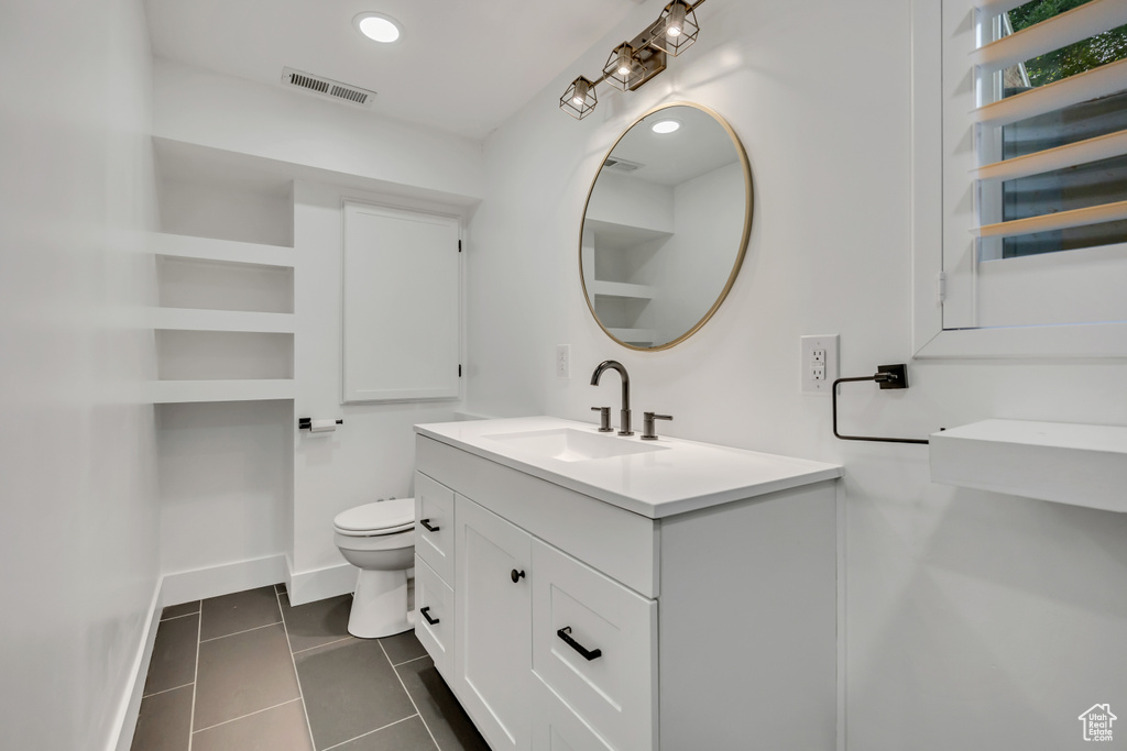 Bathroom featuring vanity, tile patterned floors, toilet, radiator, and baseboards