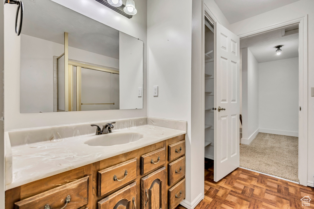 Full bathroom featuring vanity, a stall shower, and baseboards