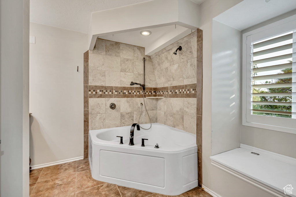 Bathroom with a bathtub, a shower, and baseboards