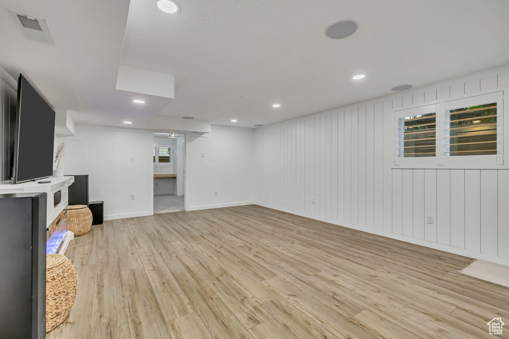 Unfurnished living room featuring light wood finished floors, baseboards, and recessed lighting