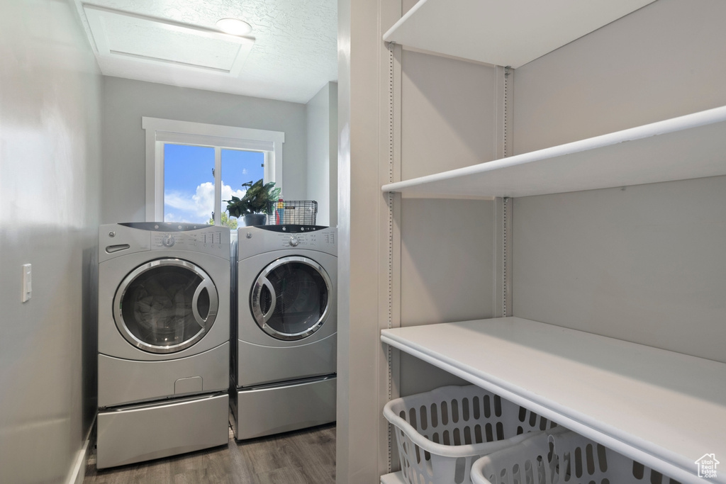 Laundry room featuring washer and dryer, attic access, wood finished floors, and a textured ceiling