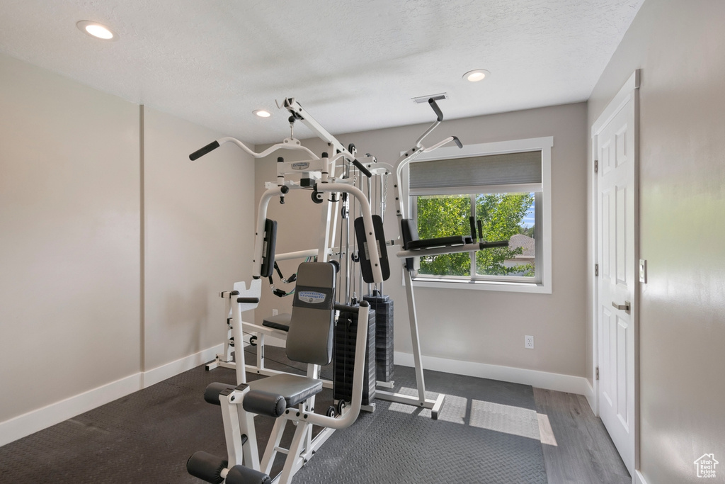 Workout room with recessed lighting, baseboards, and a textured ceiling