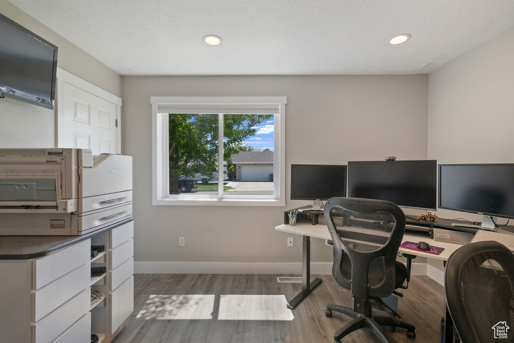 Home office featuring wood finished floors, recessed lighting, and baseboards