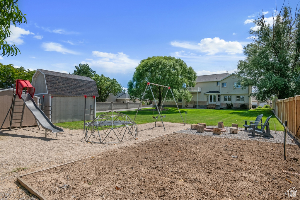 View of play area featuring an outdoor fire pit and a storage unit