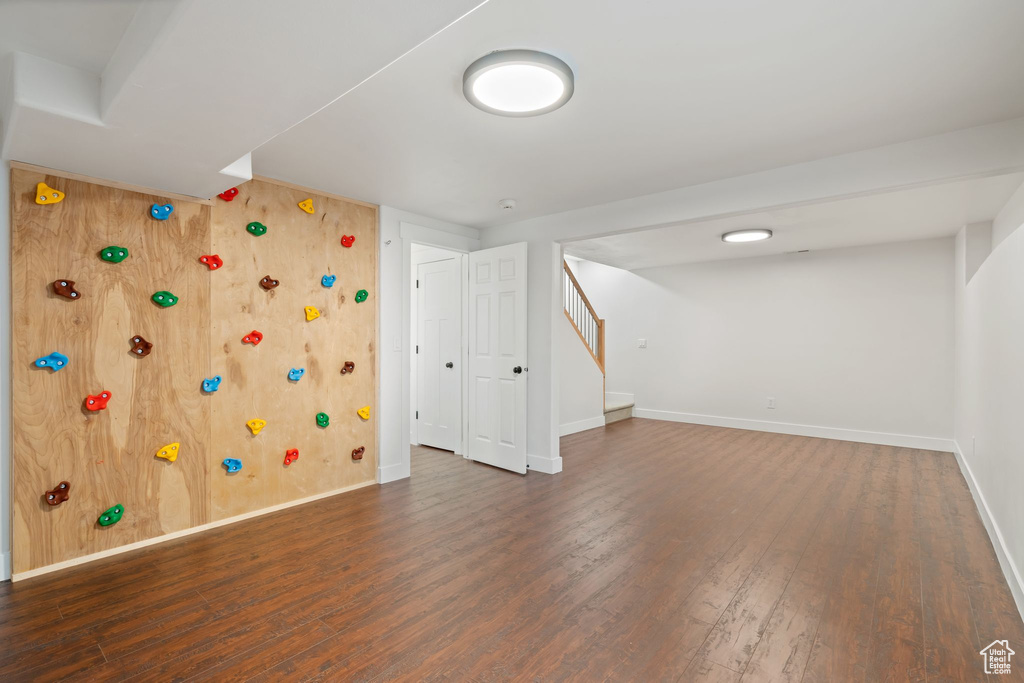 Finished below grade area featuring wood finished floors, stairway, and baseboards