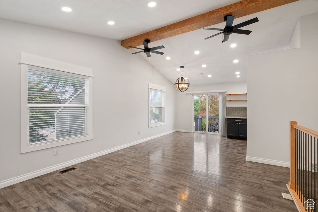 Unfurnished living room with ceiling fan, a chandelier, dark wood-style flooring, recessed lighting, and baseboards