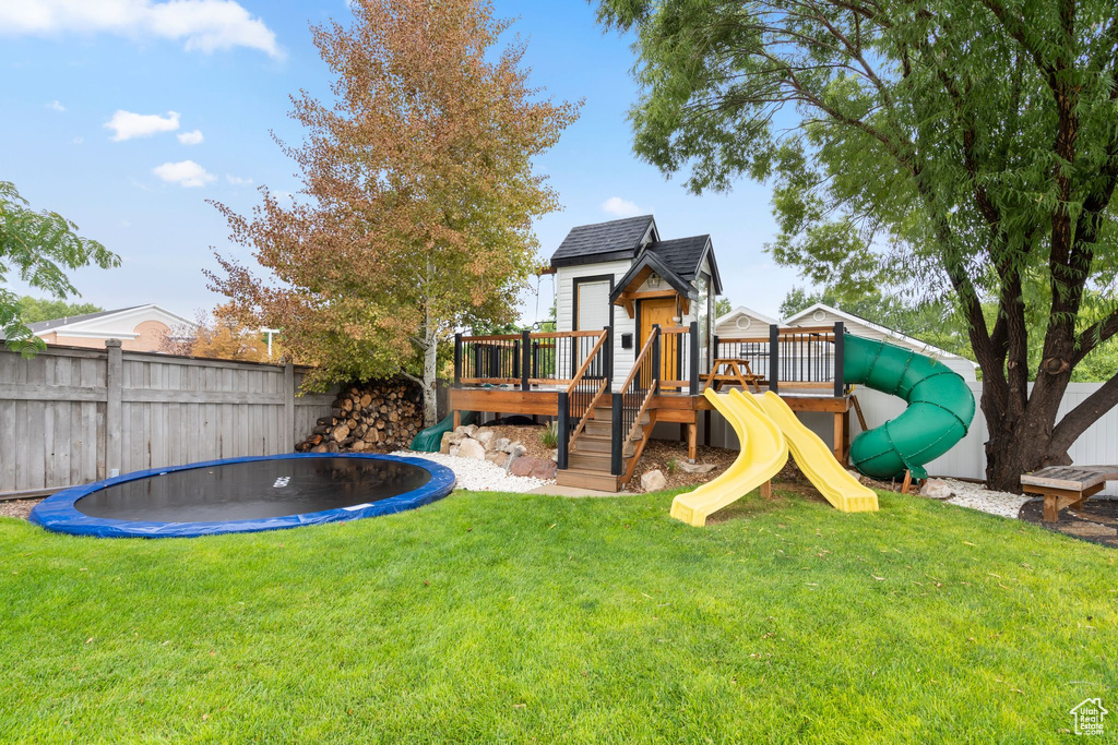 View of play area with a trampoline and a wooden deck