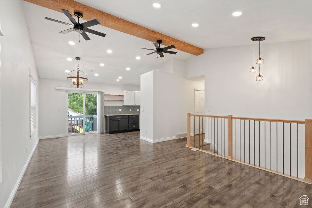 Unfurnished living room featuring ceiling fan, beam ceiling, wood finished floors, high vaulted ceiling, and baseboards