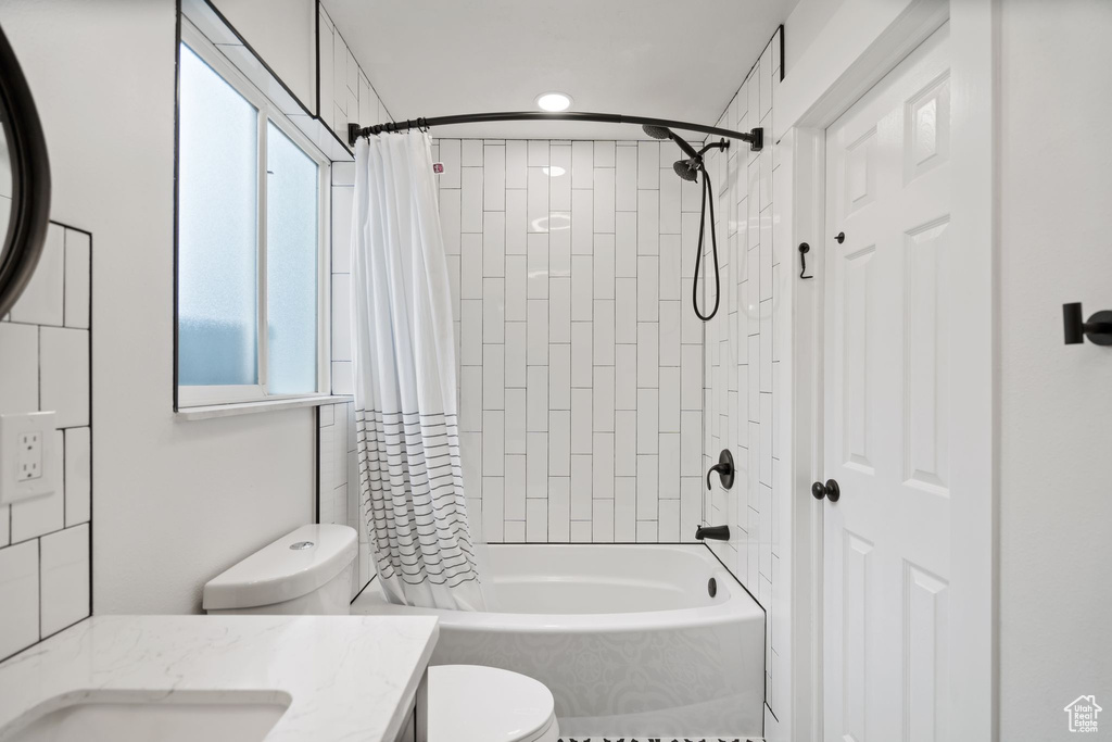 Full bathroom featuring vanity, toilet, and shower / tub combo with curtain