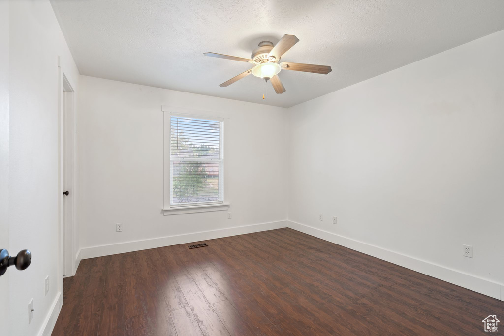 Unfurnished room with a ceiling fan, wood finished floors, and baseboards