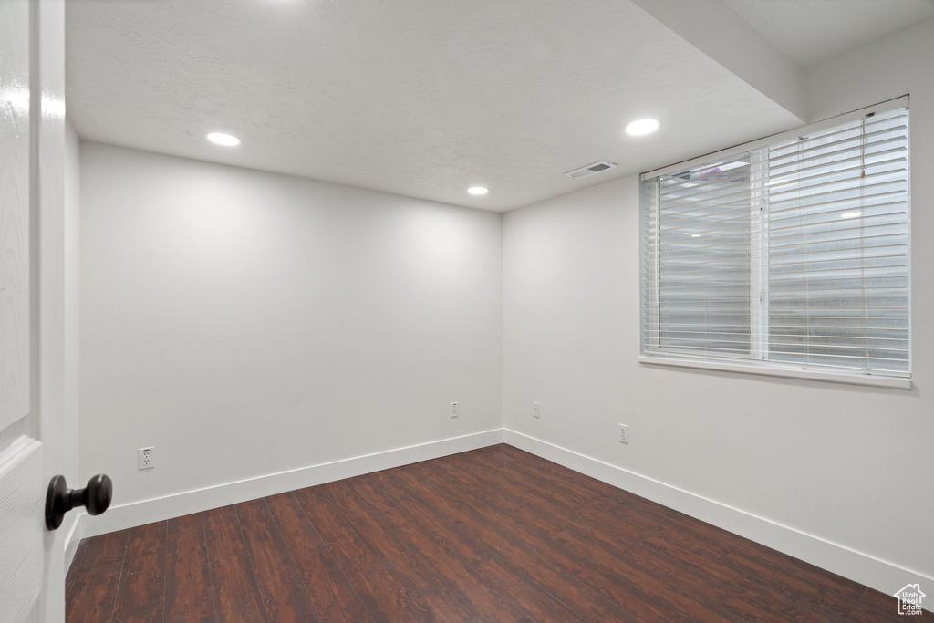 Spare room featuring dark wood finished floors, baseboards, and recessed lighting
