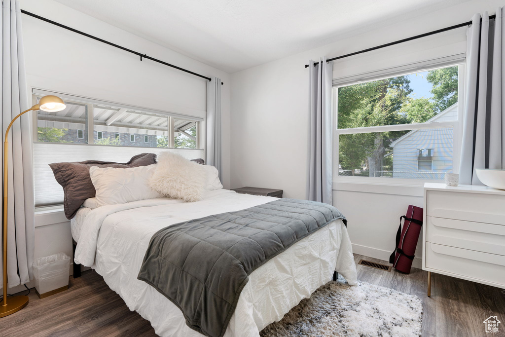Bedroom with multiple windows and wood finished floors