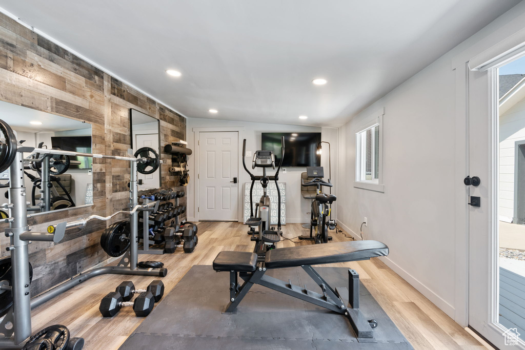 Exercise room with wood finished floors and recessed lighting