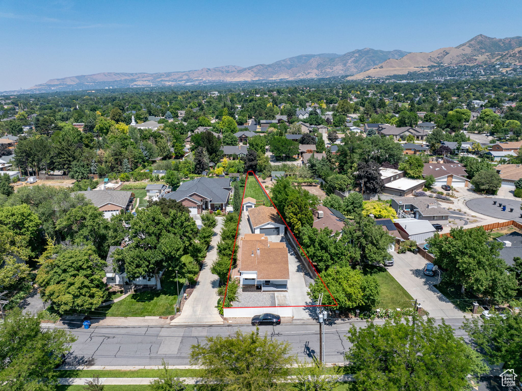Aerial view of residential area with a mountainous background and property boundaries highlighted
