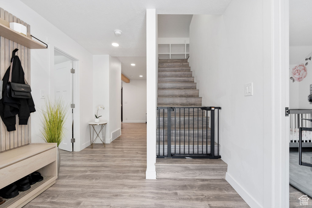 Stairway featuring wood finished floors, baseboards, and recessed lighting