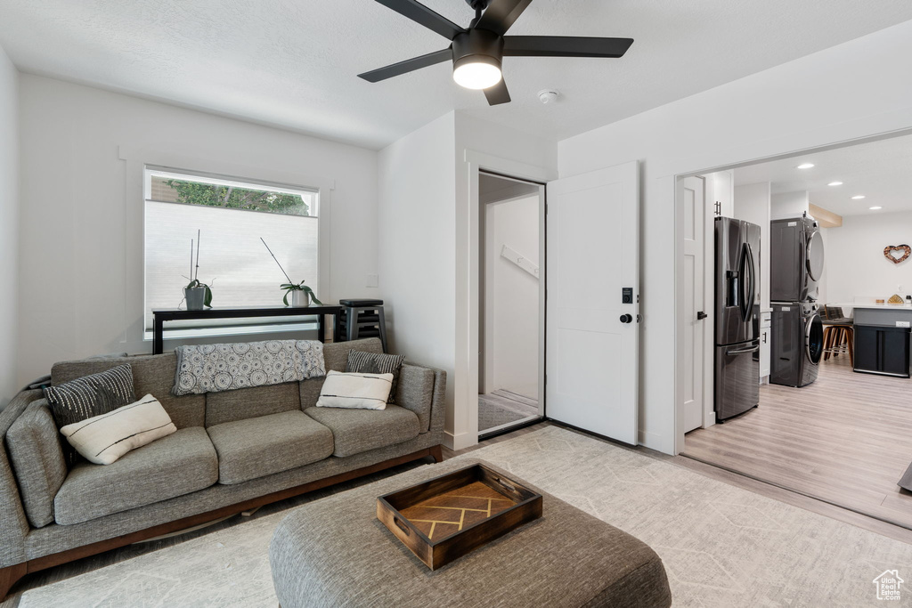 Living room with estacked washer and dryer, ceiling fan, recessed lighting, and light wood-type flooring