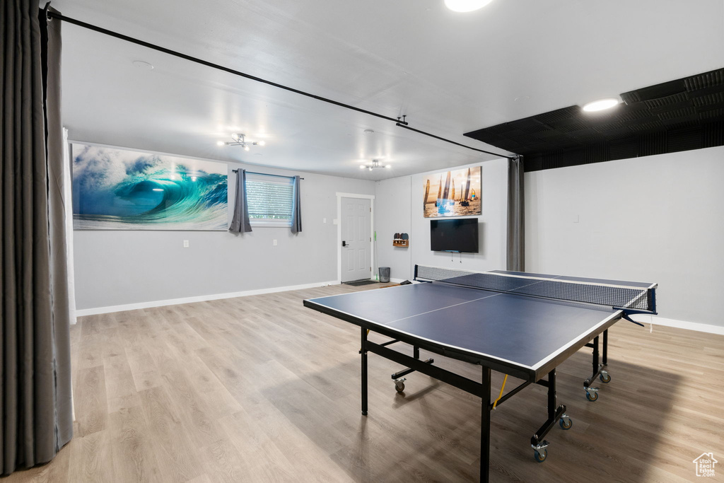 Game room with baseboards and light wood-style flooring