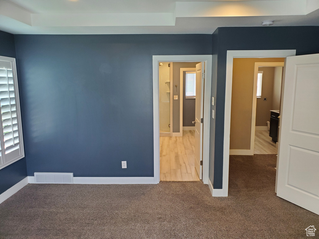 Unfurnished bedroom featuring carpet floors, multiple windows, and baseboards