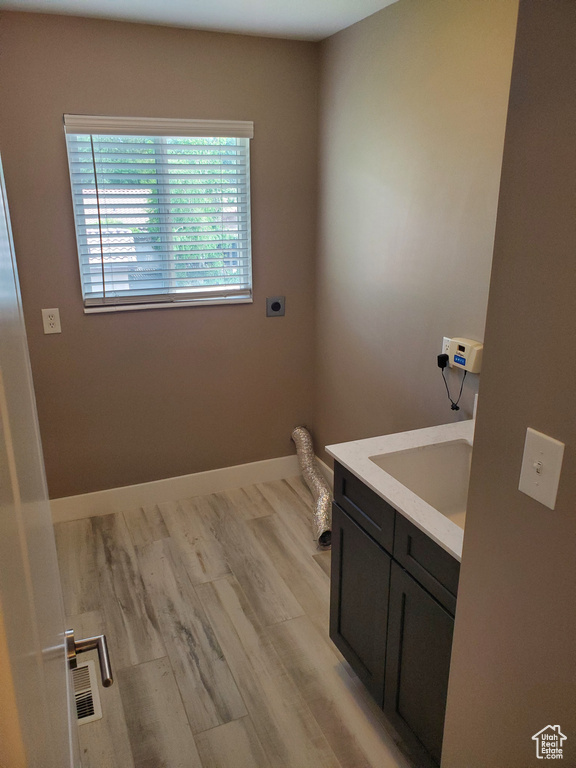 Bathroom featuring vanity, wood finished floors, and baseboards