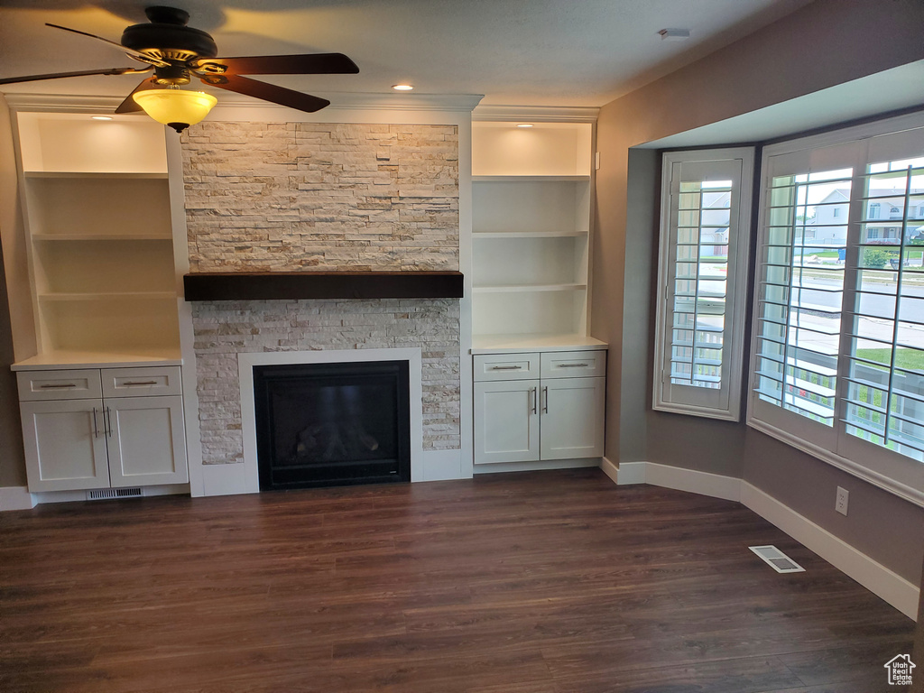 Unfurnished living room with baseboards, healthy amount of natural light, dark wood finished floors, and a ceiling fan